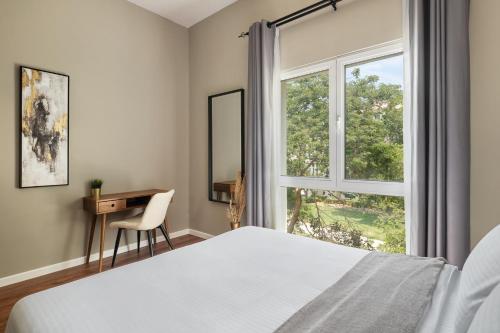 a bedroom with a bed and a window at Chic studio near metro at Discovery Gardens in Dubai