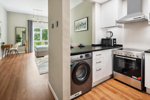a kitchen and living room with a washer and dryer at Chic studio near metro at Discovery Gardens in Dubai
