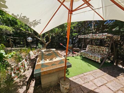 a garden with a swing and an umbrella at Il Giardino in Calvello