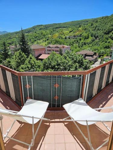 two white chairs sitting on a balcony with a view at Il Giardino in Calvello