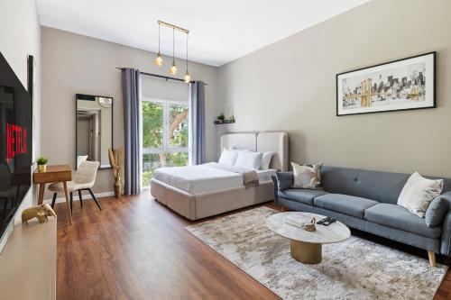 a living room with a couch and a bed at Chic studio near metro at Discovery Gardens in Dubai