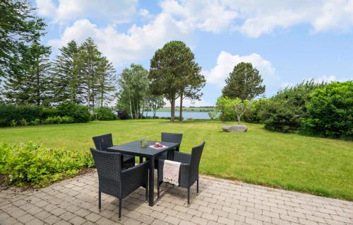 a black table and chairs on a patio with a field at Awesome Home In Roskilde With Wifi in Roskilde