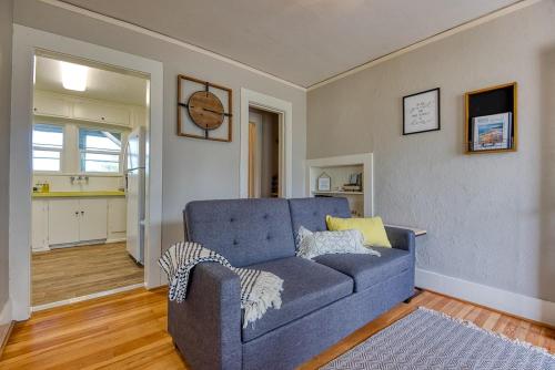 a living room with a blue couch and a kitchen at #StayinMyDistrict Heritage By The Bay in Coos Bay