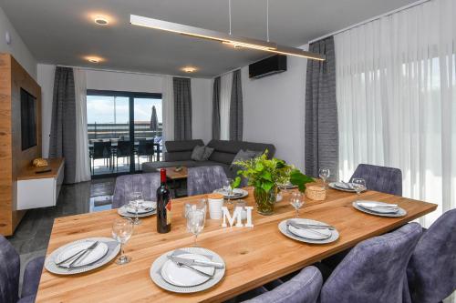 a dining room table with plates and wine glasses at Holiday Villa MI in Orebić
