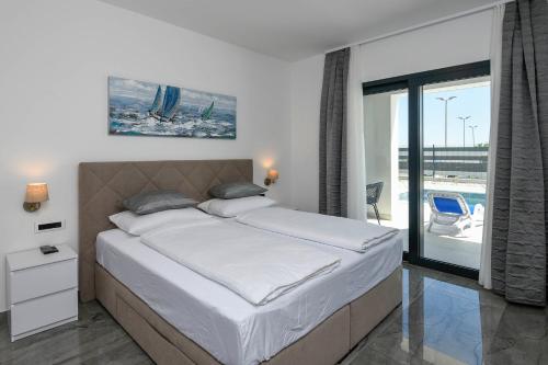 a large bed in a bedroom with a balcony at Holiday Villa MI in Orebić