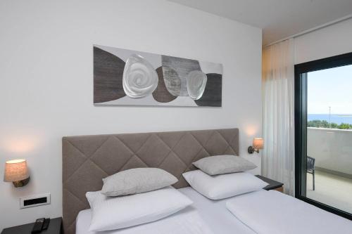 a bedroom with a bed with two white pillows at Holiday Villa MI in Orebić