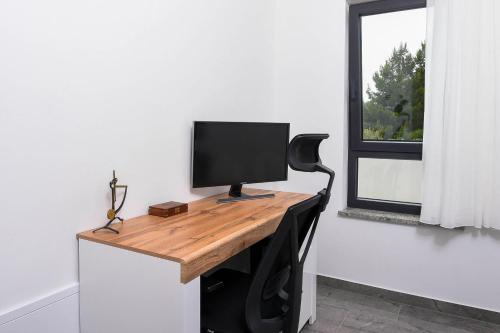 a computer monitor on a desk in a room with a window at Holiday Villa MI in Orebić