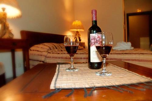 a bottle of wine and two glasses on a table at Agathi in Pramanta