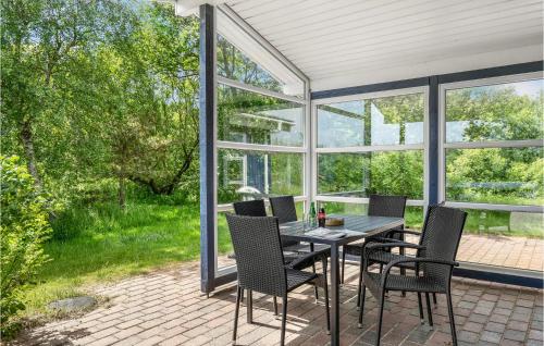 un patio con tavolo, sedie e finestre di Holiday Home Tovtvej Fanø Ii a Fanø