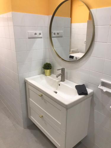 a white bathroom with a sink and a mirror at Apartamento Torreón in Foz