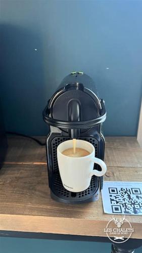 a coffee maker with a cup of coffee on a table at Le2089 - Spa et plage - Les chalets dans le nord in Sainte-Lucie-de-Doncaster