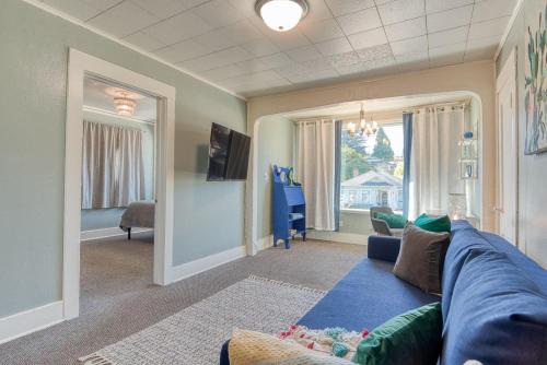 a living room with a blue couch and a window at #StayinMyDistrict Heritage House Suite in Coos Bay