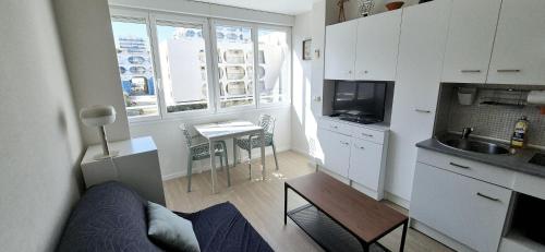 - une cuisine avec un canapé et une table dans une chambre dans l'établissement Le beaulieu design cosy clim centre ville, à La Grande Motte