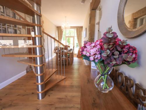 a vase of flowers on a table in a hallway at Clock Tower in Grange Over Sands