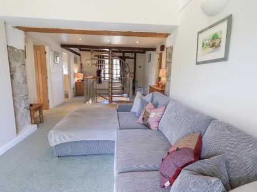 a living room with a blue couch with pillows at Clock Tower in Grange Over Sands