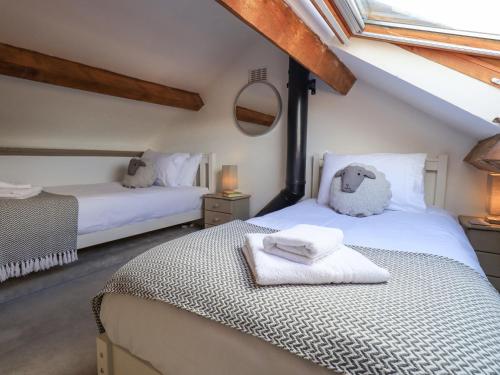 a bedroom with two beds with towels on them at Clock Tower in Grange Over Sands