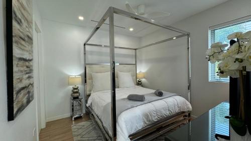 ein Schlafzimmer mit einem Himmelbett in einem Zimmer in der Unterkunft 2bdr Seven Mile Beach Corridor - ONE Canal Resort in George Town