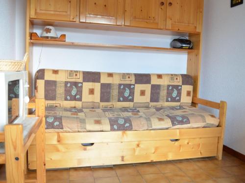 un lit avec un cadre en bois dans une chambre dans l'établissement Charmant 2 pièces avec parking, proche télésiège et navettes - FR-1-676-101, à Châtel