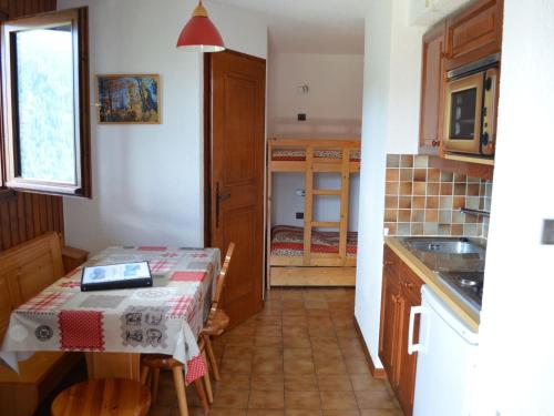 une cuisine avec une table recouverte d'une nappe dans l'établissement Charmant 2 pièces avec parking, proche télésiège et navettes - FR-1-676-101, à Châtel