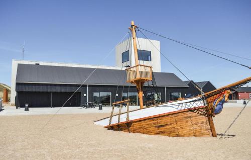 a wooden boat on display in front of a building at Holiday Home Fjand Strand Ulfborg Iv in Fjand Gårde