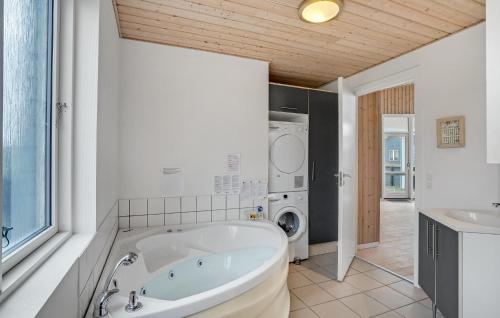a bathroom with a tub and a washing machine at Holiday Home Fjand Strand Ulfborg Iv in Fjand Gårde