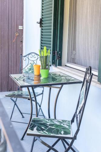una mesa de cristal y 2 sillas en un porche en B&B La Casa di Carolina, en Maratea