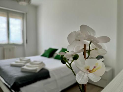 a white flower in a vase next to a bed at La casa di Paolo - Bollate centro in Bollate
