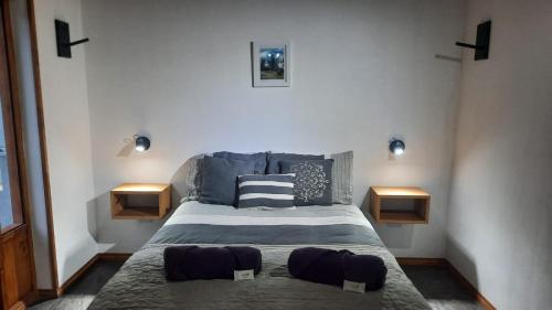 a bedroom with a large bed with two night stands at Departamento El Origen-SMA in San Martín de los Andes
