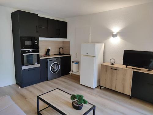 Il comprend une cuisine et un salon avec un réfrigérateur blanc. dans l'établissement Le Village Camarguais pour 4 avec piscine et animations, idéal famille, à Arles