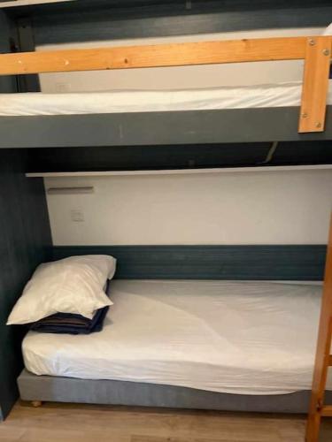 - un lit superposé avec un oreiller sur la couchette inférieure dans l'établissement Le Village Camarguais pour 4 avec piscine et animations, idéal famille, à Arles