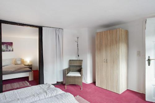 a bedroom with a bed and a chair and a cabinet at Gästehaus Roth in Willingen