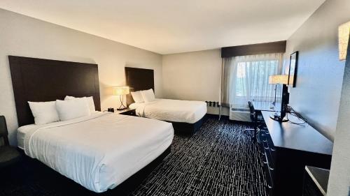 a hotel room with two beds and a desk at La Quinta Inn by Wyndham Sheboygan in Sheboygan