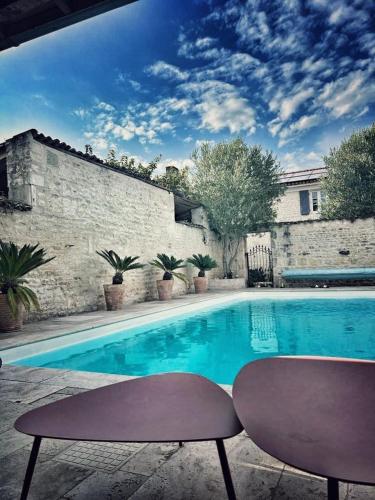 - une piscine avec 2 chaises à côté d'un bâtiment dans l'établissement Gîte Le 240b, à Saint-Mard