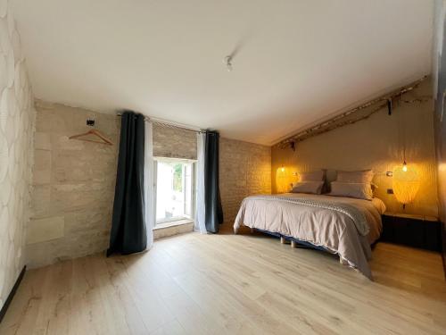 une chambre avec un grand lit et une fenêtre dans l'établissement Gîte Le 240b, à Saint-Mard