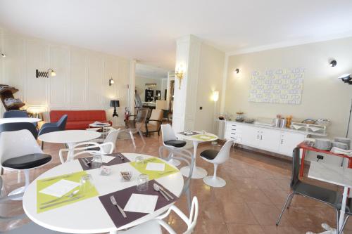 a living room with tables and chairs and a kitchen at Hotel Tourist in Turin