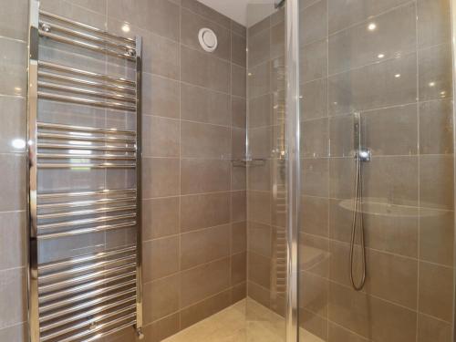 a shower with a glass door in a bathroom at Meadow Syke Barn in Penrith