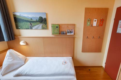 a room with a bed and a picture on the wall at JUFA Hotel Kaprun - Summercard included in Kaprun