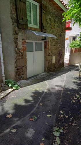 a white garage door on a stone building at Le pat' toit in Aurec-sur-Loire