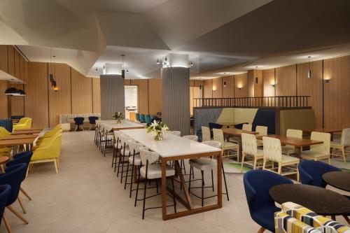 a dining room with tables and chairs at Home2 Suites By Hilton New York Times Square in New York