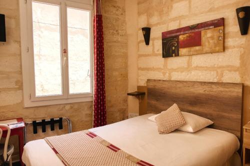 a bedroom with a bed and a window at Hôtel Boquier, Avignon Centre in Avignon