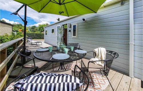 a patio with a table and chairs and an umbrella at 2 Bedroom Nice Home In Heinkenszand in Heinkensand