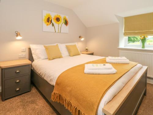 una camera da letto con un letto con due asciugamani sopra di Small Lane Cottage a Endon