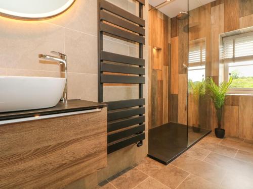 un bagno con lavandino e specchio di Small Lane Cottage a Endon