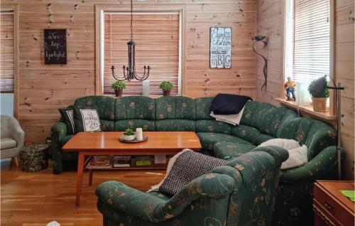a living room with a green couch and a table at 3 Bedroom Beautiful Home In Flekkerøy in Ytre Skålevik