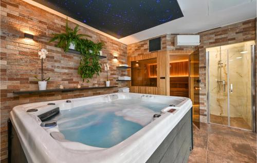 a large bath tub in a bathroom with at Beautiful Home In Kelemen With Sauna in Kelemen