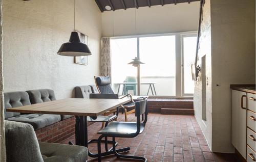 a dining room with a table and chairs and a window at Feriehotal Tranum Klit in Brovst