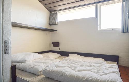 two unmade beds in a room with a window at Feriehotal Tranum Klit in Brovst