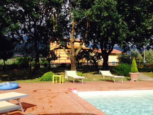 - une piscine avec 2 chaises et une table dans l'établissement Villa Monnalisa, à Pian di Scò