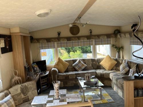 a living room with a couch and a table at Hornshole Hideaway Caravan Hawick in Hawick