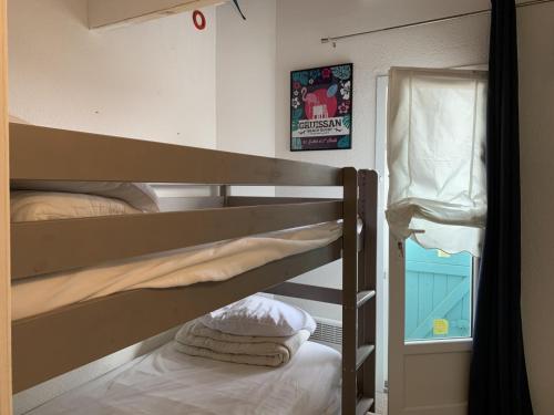 une chambre avec deux lits superposés et une fenêtre dans l'établissement Villa Confortable 6 Pers. Climatisée, Proche Plage du Grazel, Calme, Tout Équipée, Stationnement Inclus - FR-1-796-71, à Gruissan